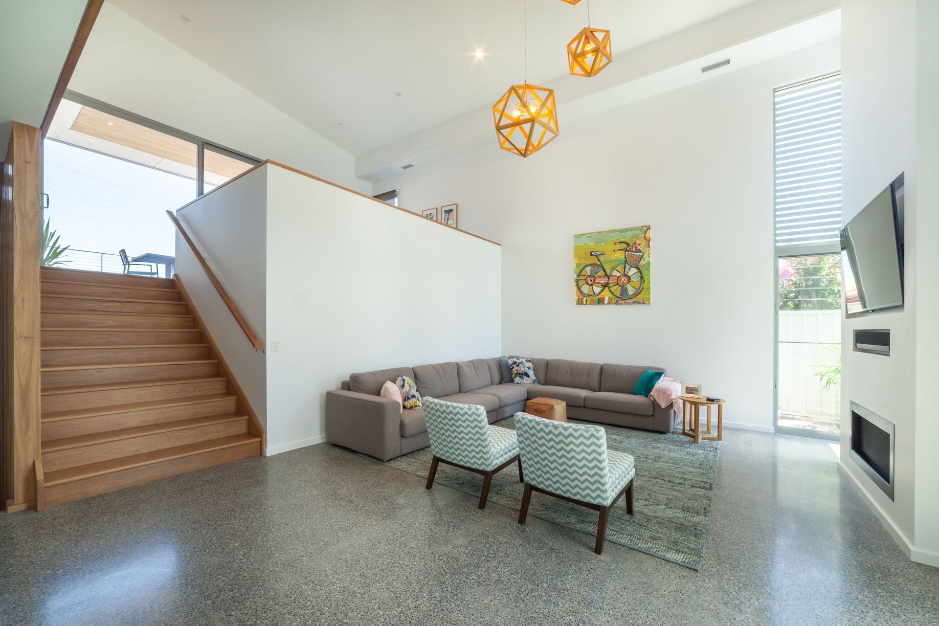 Staircase with wooden steps and white risers, wooden banister and trim, next to a decorated cabinet.