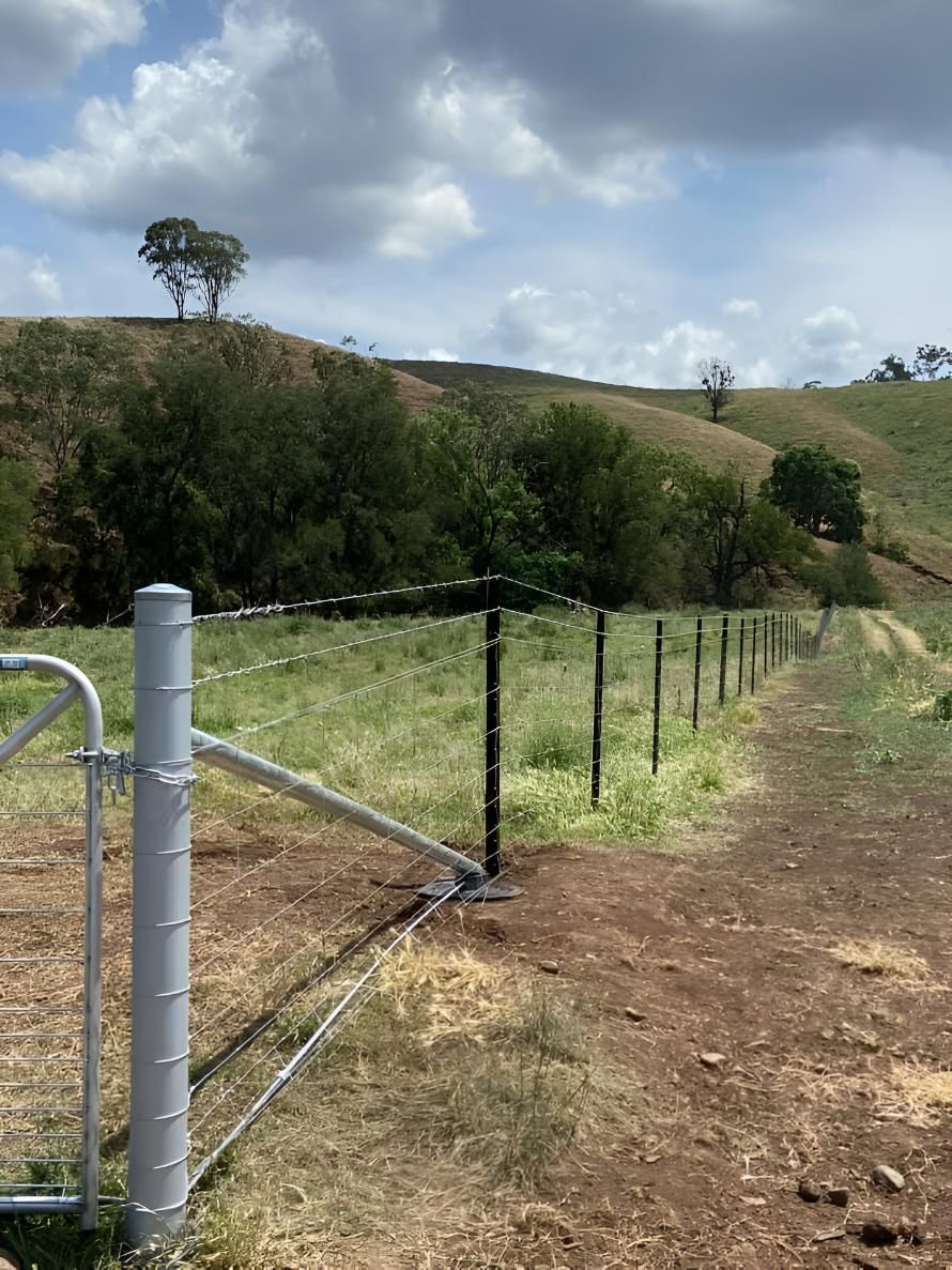 There is a Fence in the Middle of a Field With Trees in the Background — MacCallum & Company In Scone, NSW