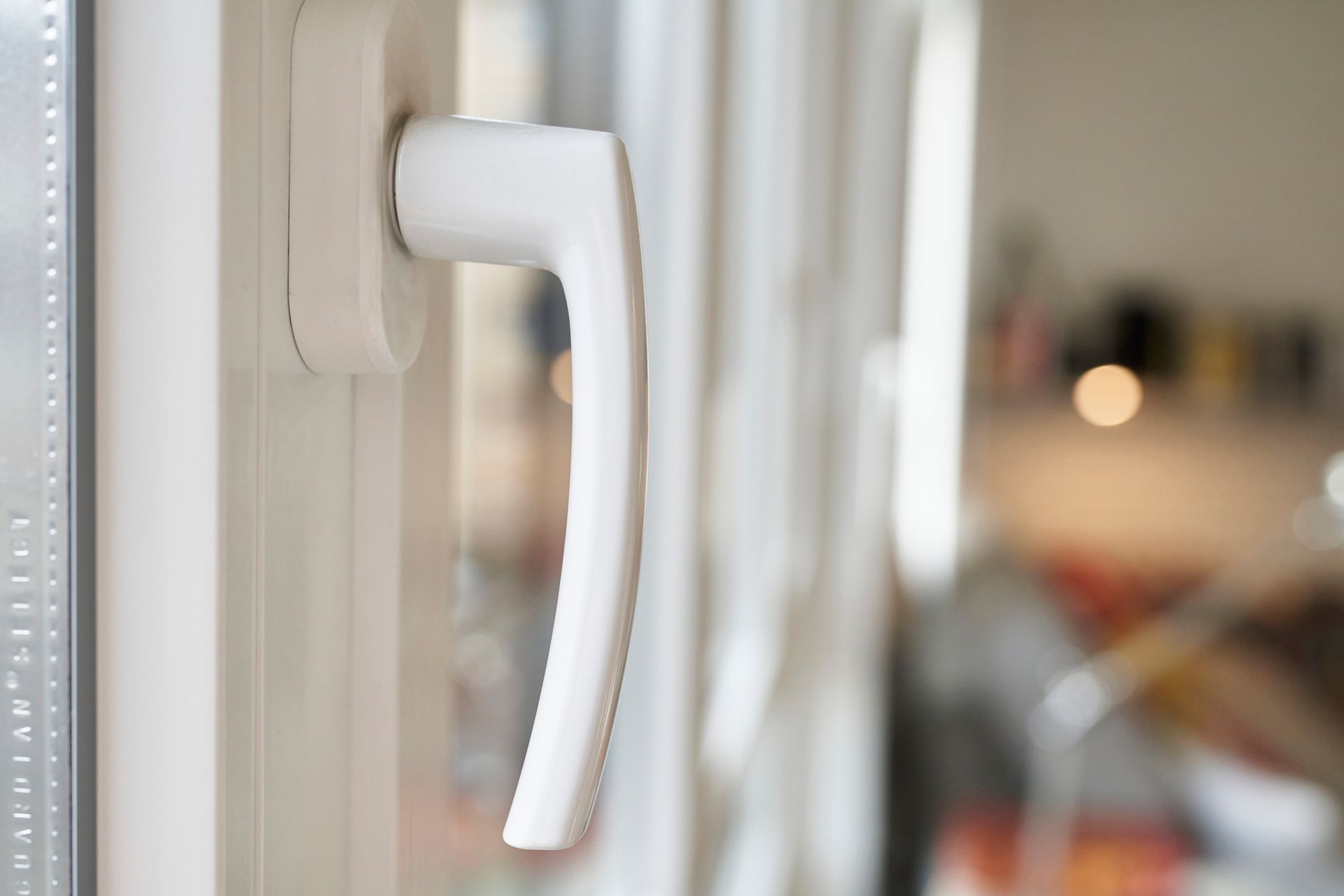 Closeup to a white window handle in a home