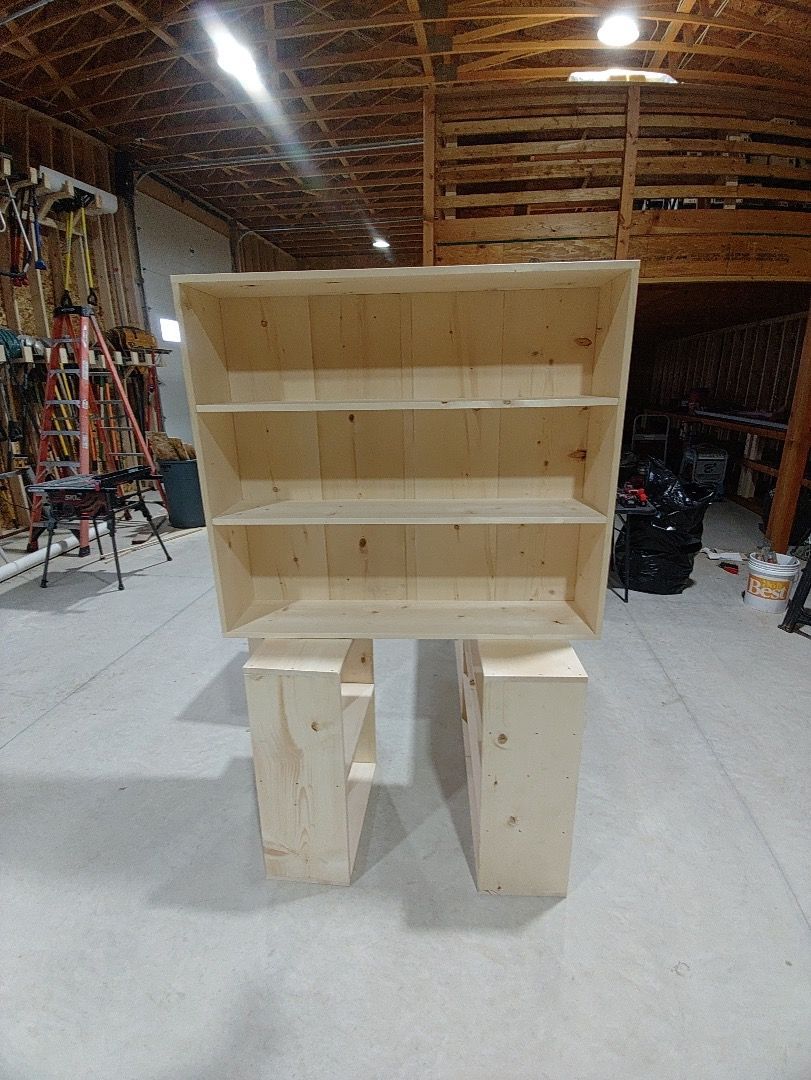 Wooden bookshelf in a workshop, built on two supporting legs.
