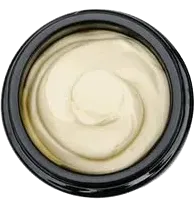 Top-down view of a jar of creamy off-white skincare cream with a swirl on top