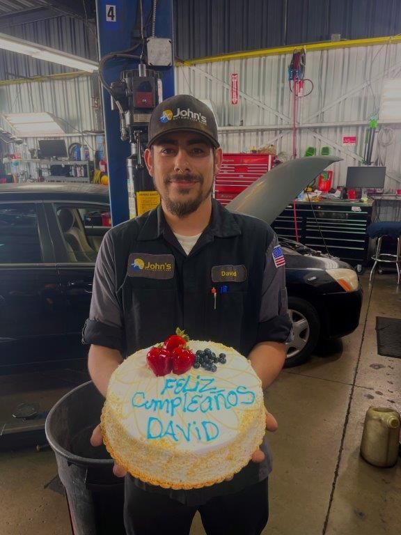 Mechanic holding a cake that says 