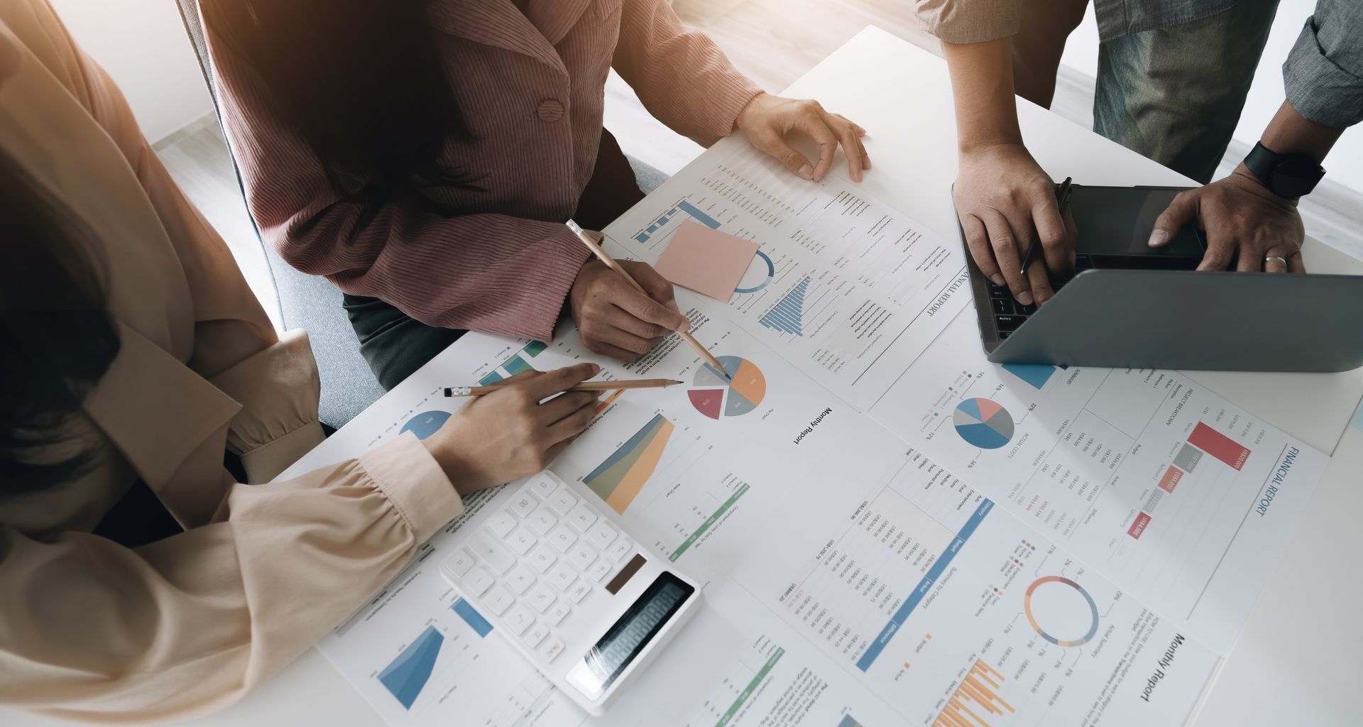 People collaborating over business documents, analyzing charts and graphs.