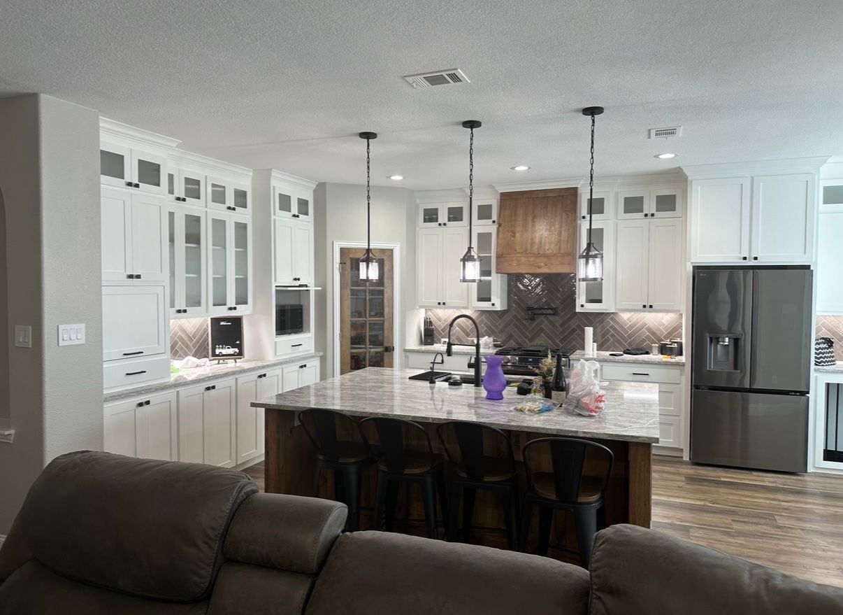 A living room with a couch and a kitchen in the background.