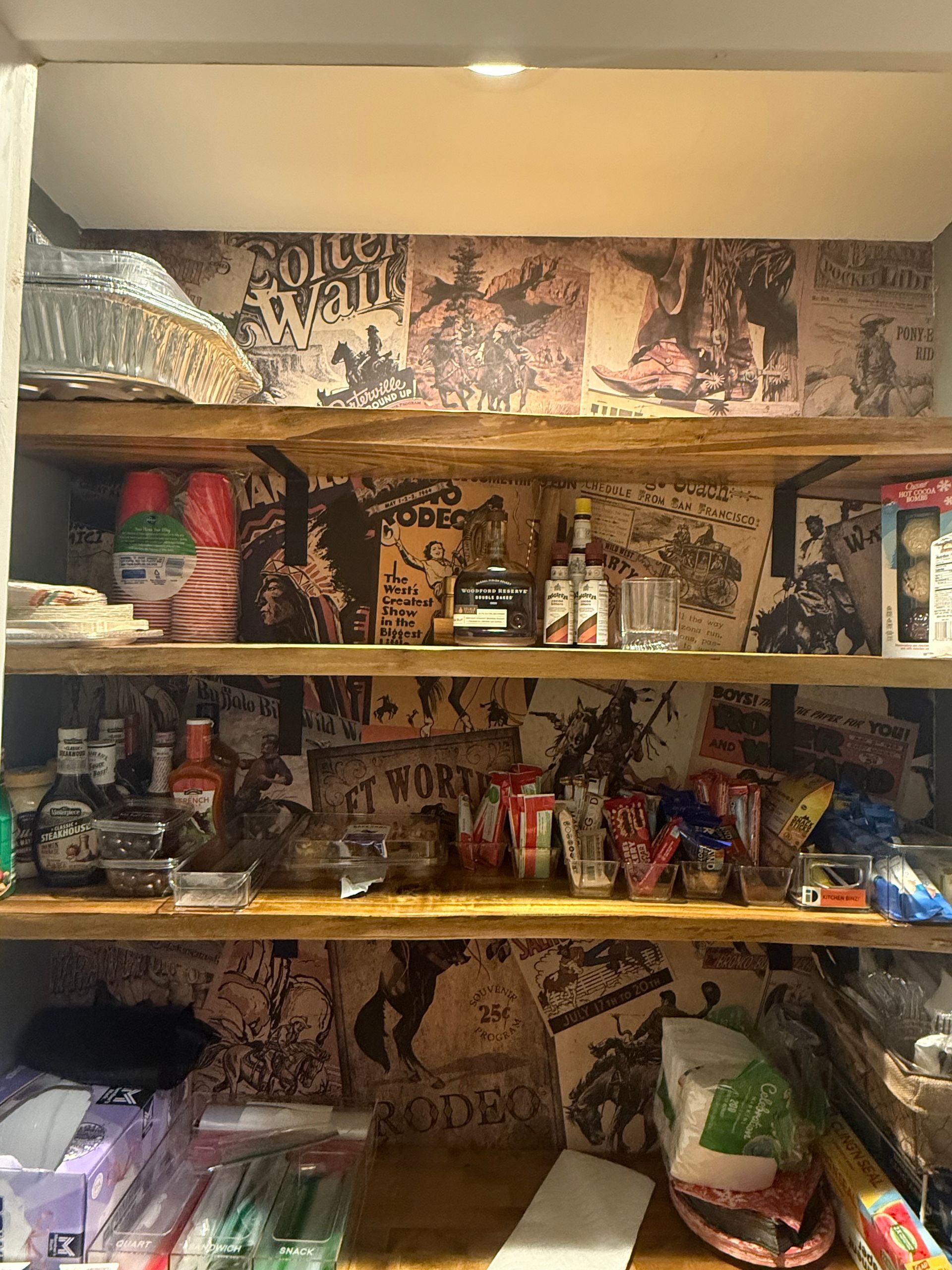 A pantry filled with lots of food and posters on the wall.