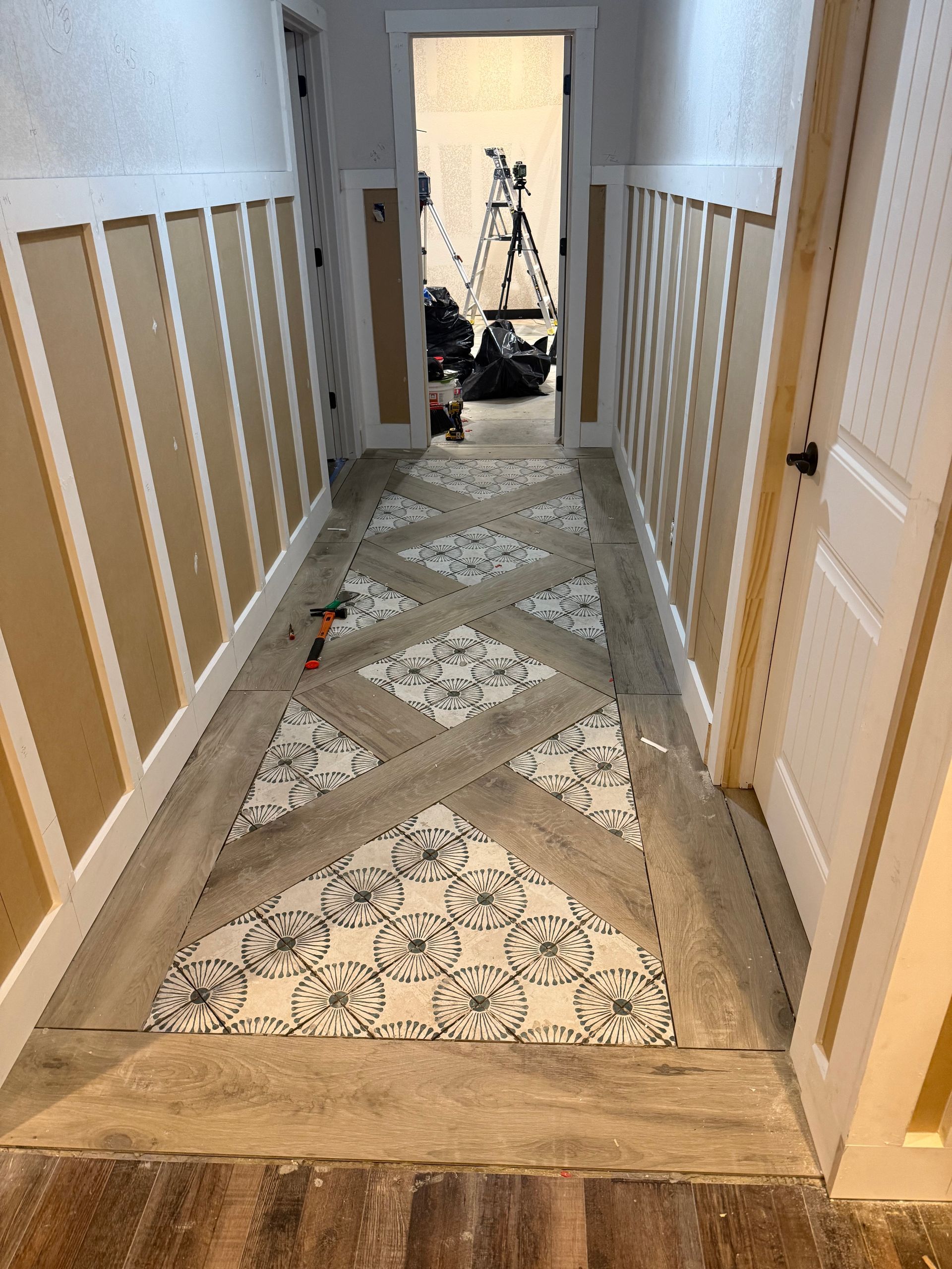 A hallway with a rug on the floor and a camera on the wall.