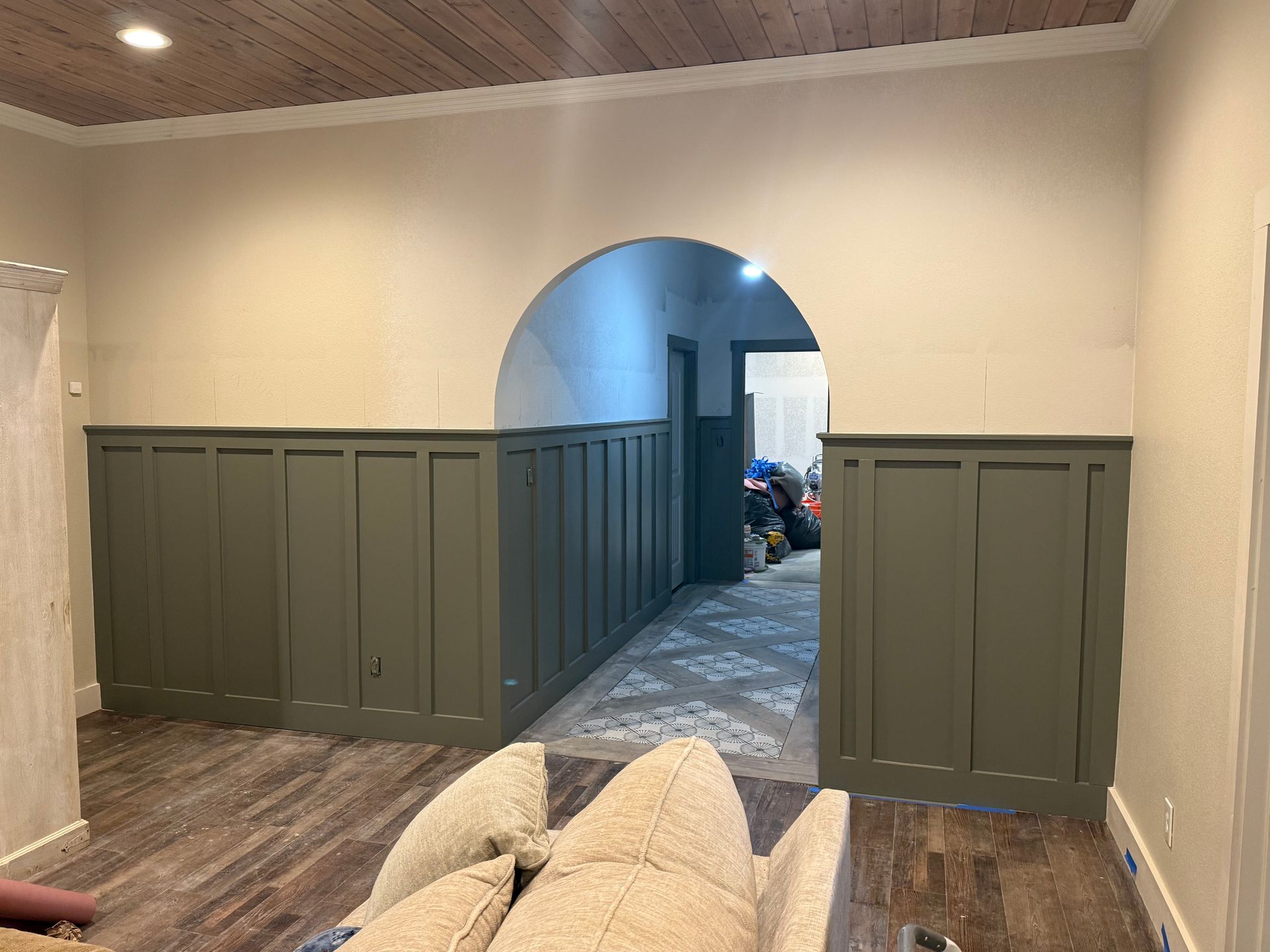 A living room with a couch and a doorway leading to a hallway.