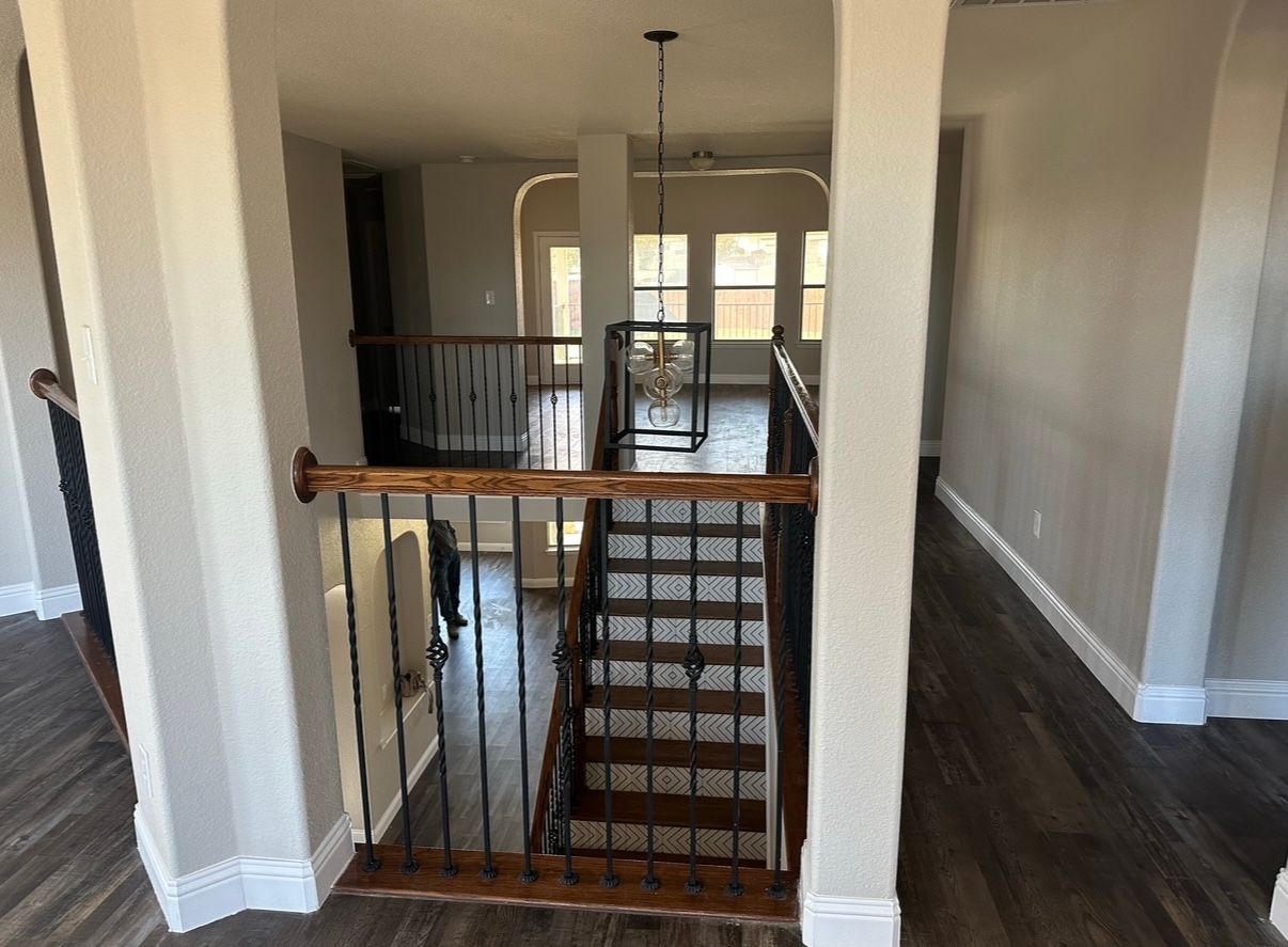 A wooden staircase with a metal railing in a house.