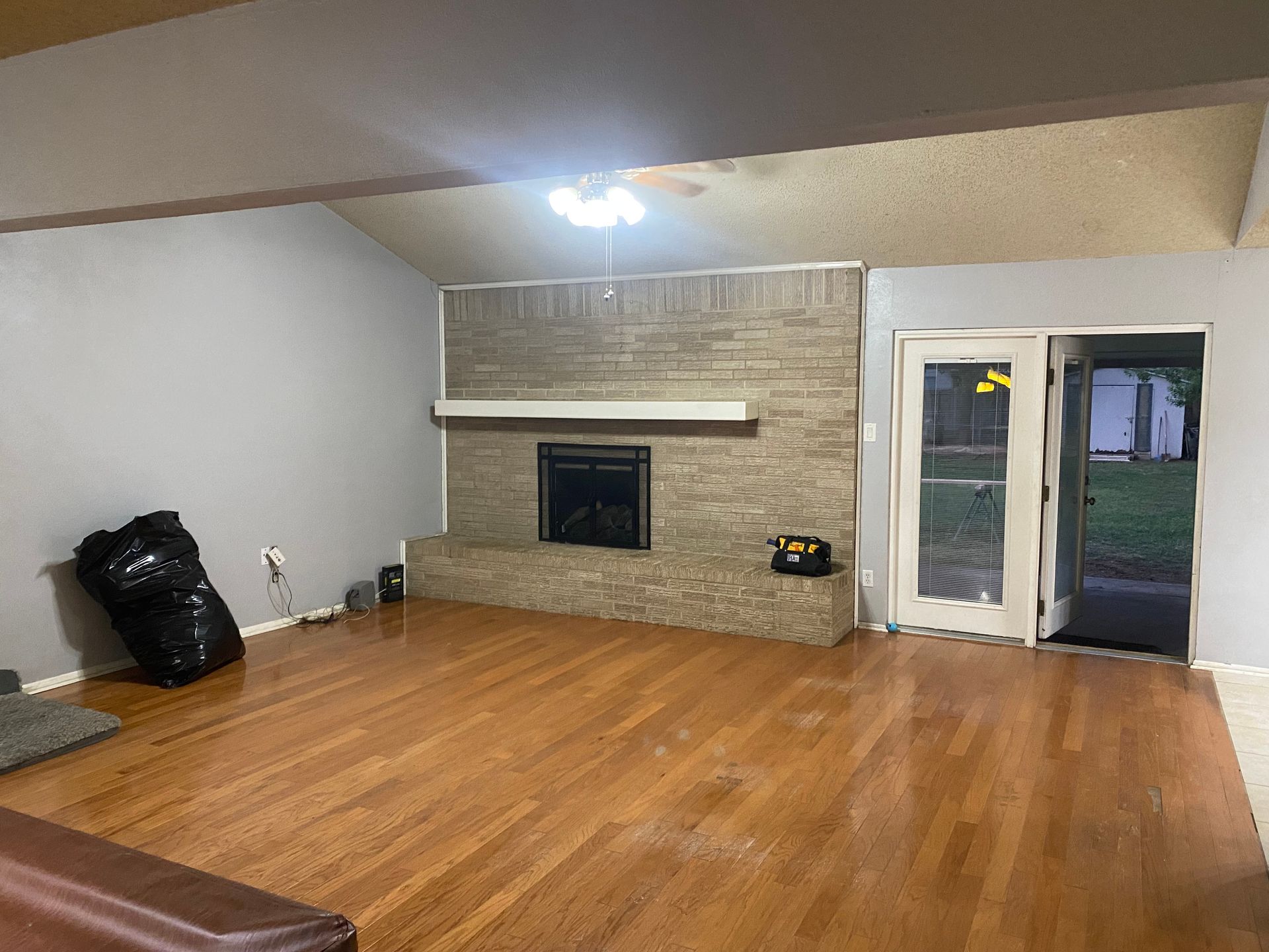 A living room with hardwood floors and a fireplace.