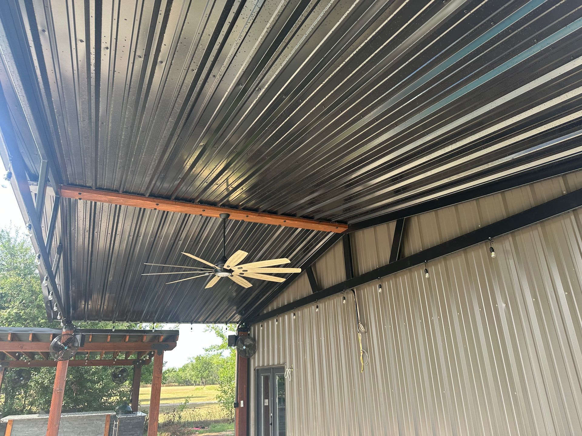 A ceiling fan is hanging from the roof of a building.