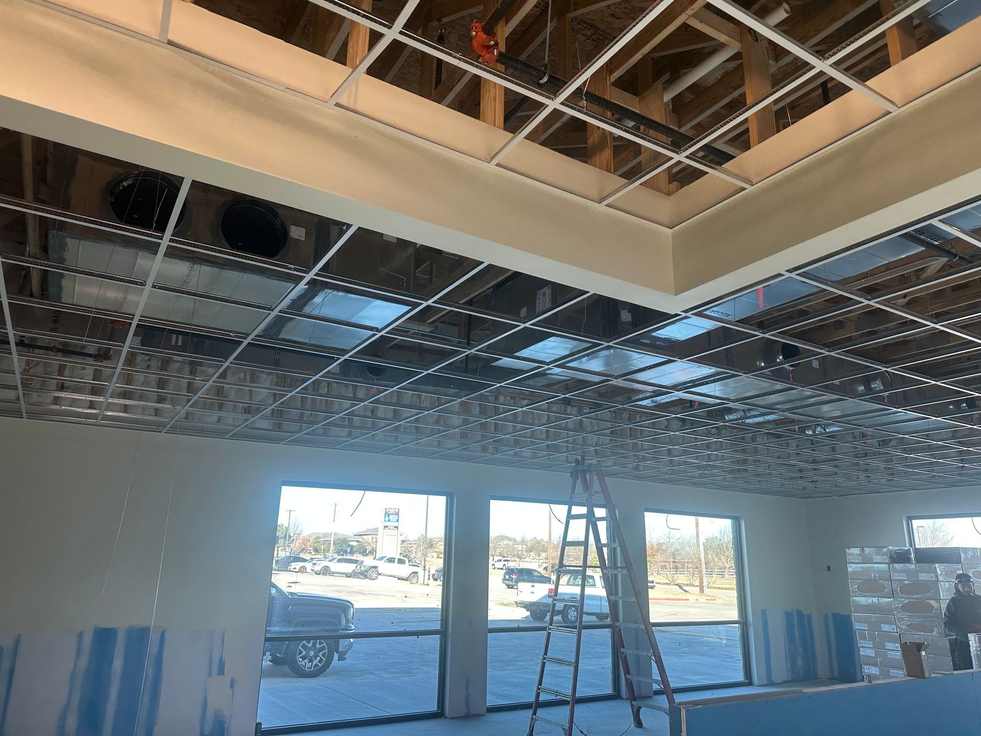 A room with a ladder in it and a ceiling that is being built.