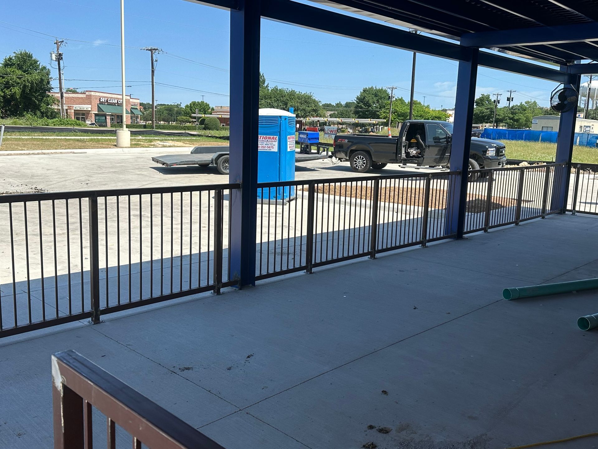A truck is parked in a parking lot behind a fence
