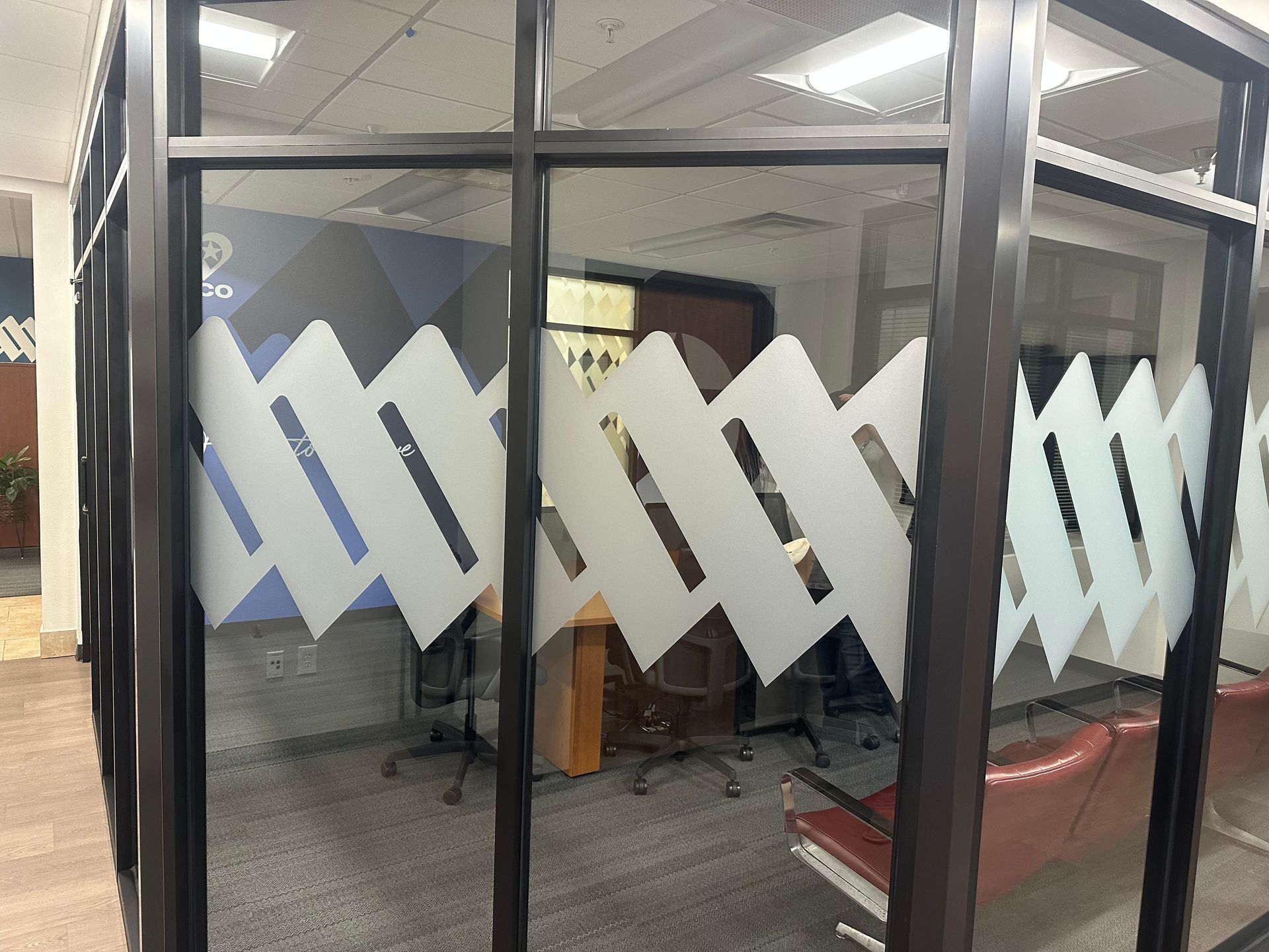 A room with a lot of windows and a table and chairs in it.