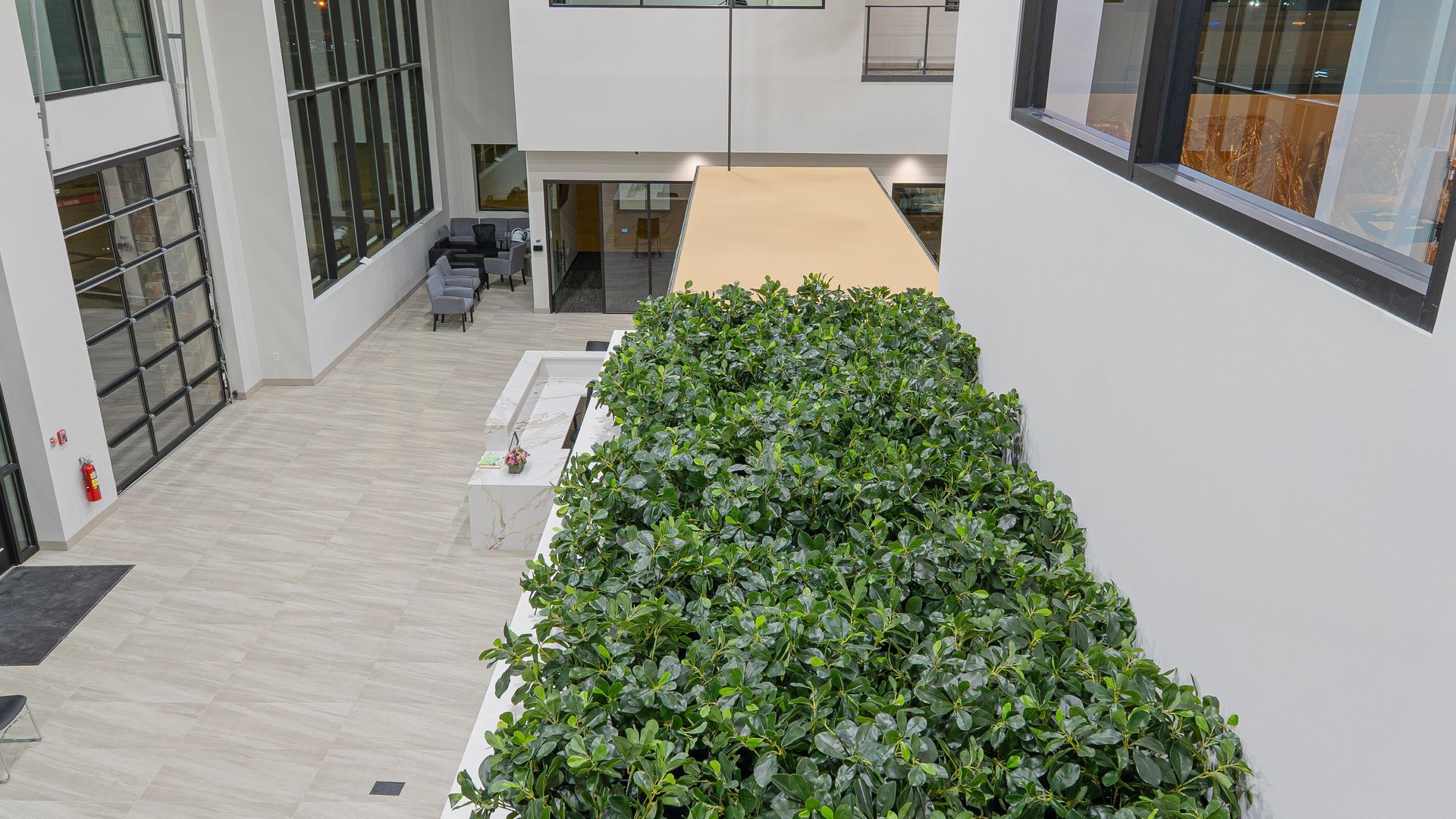 A large building with a lot of windows and plants in the middle of it.