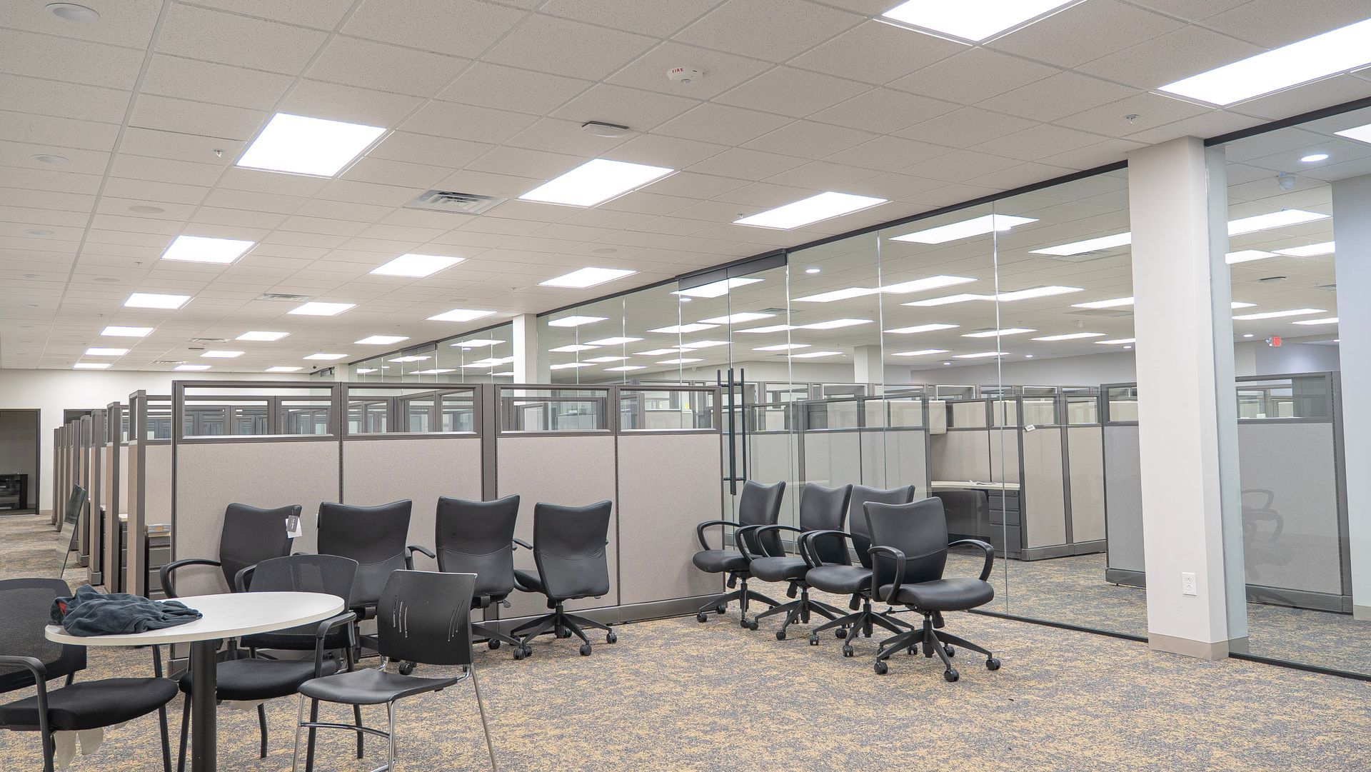 A large room with cubicles and chairs in it