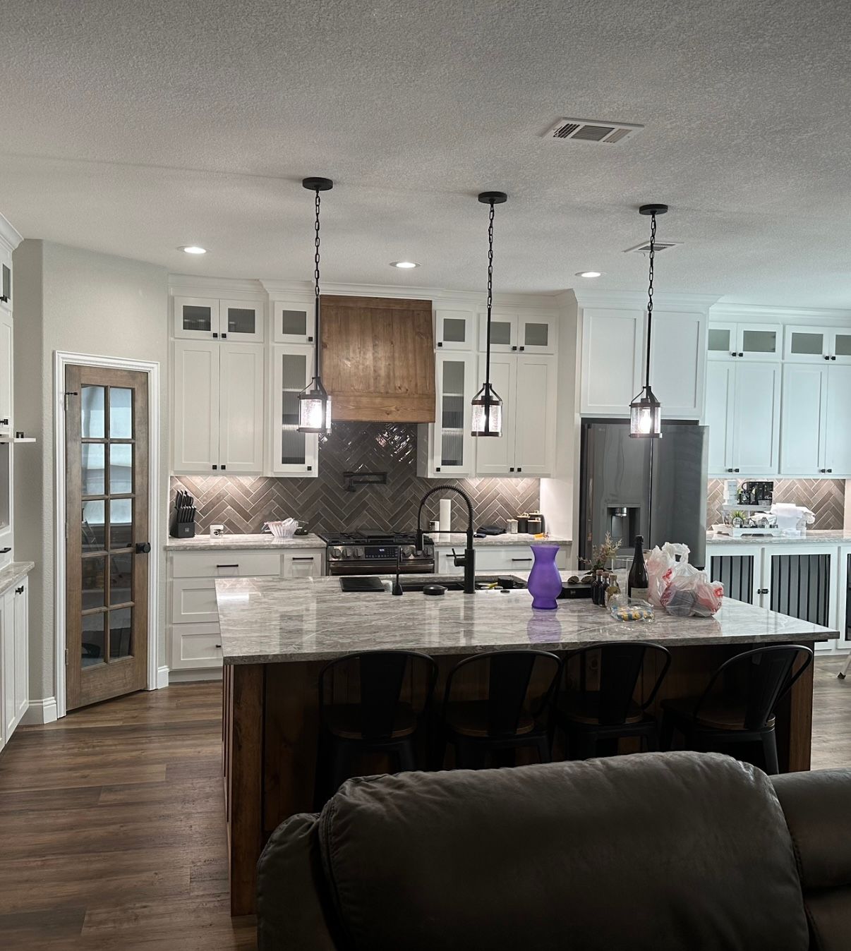 A kitchen with white cabinets and a large island