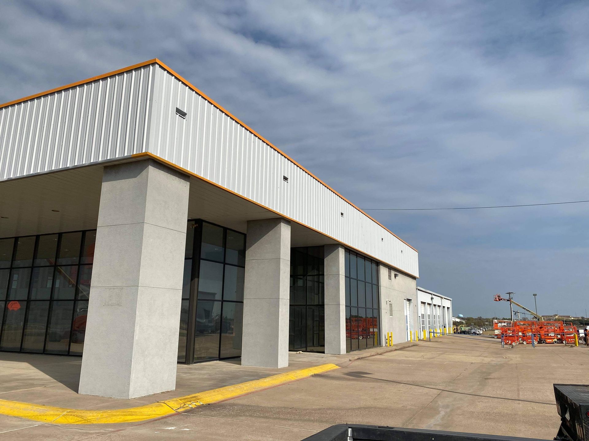 A large white building with a lot of windows and a yellow curb.