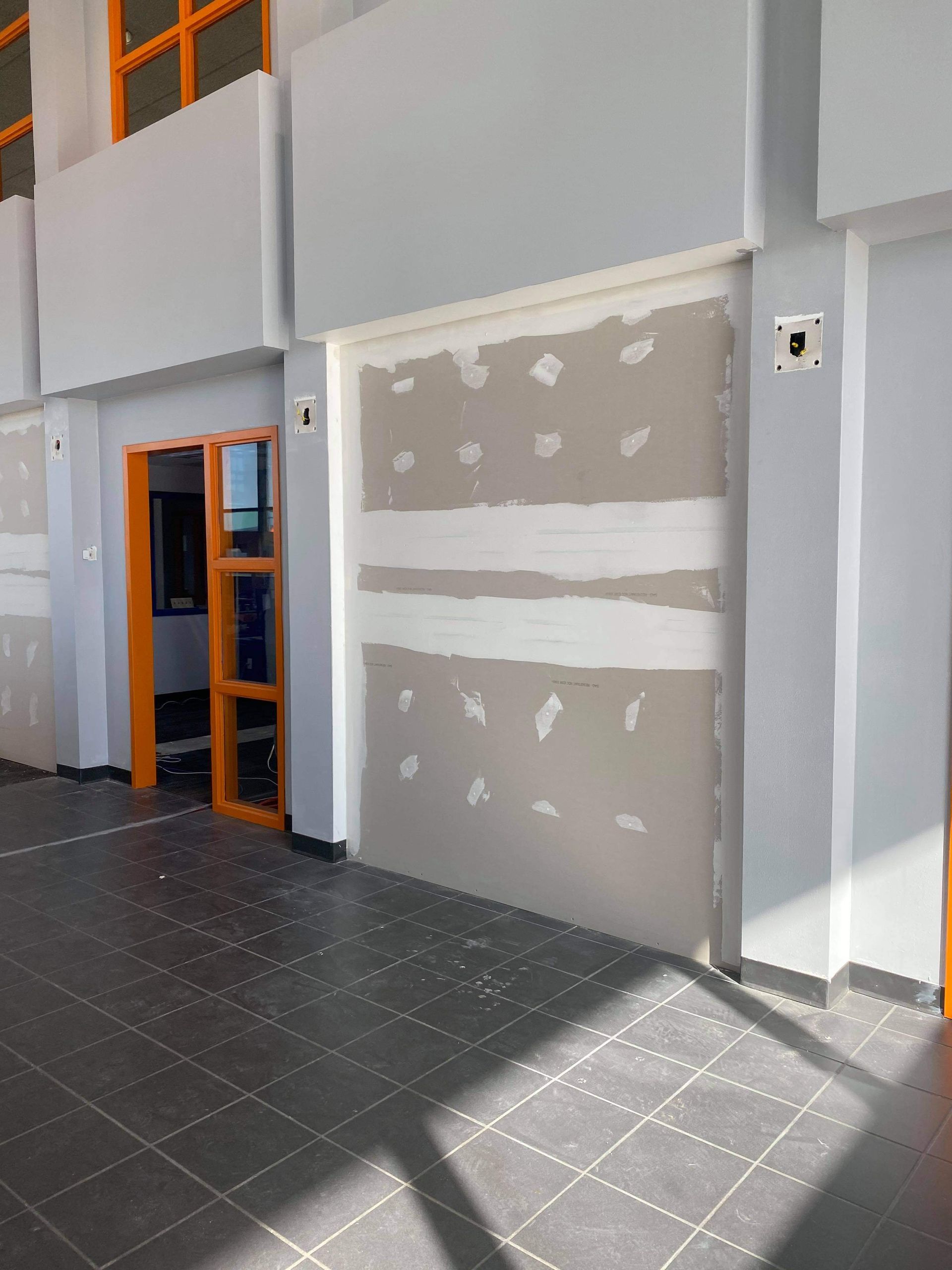 A building that is being remodeled and has a shadow on the floor