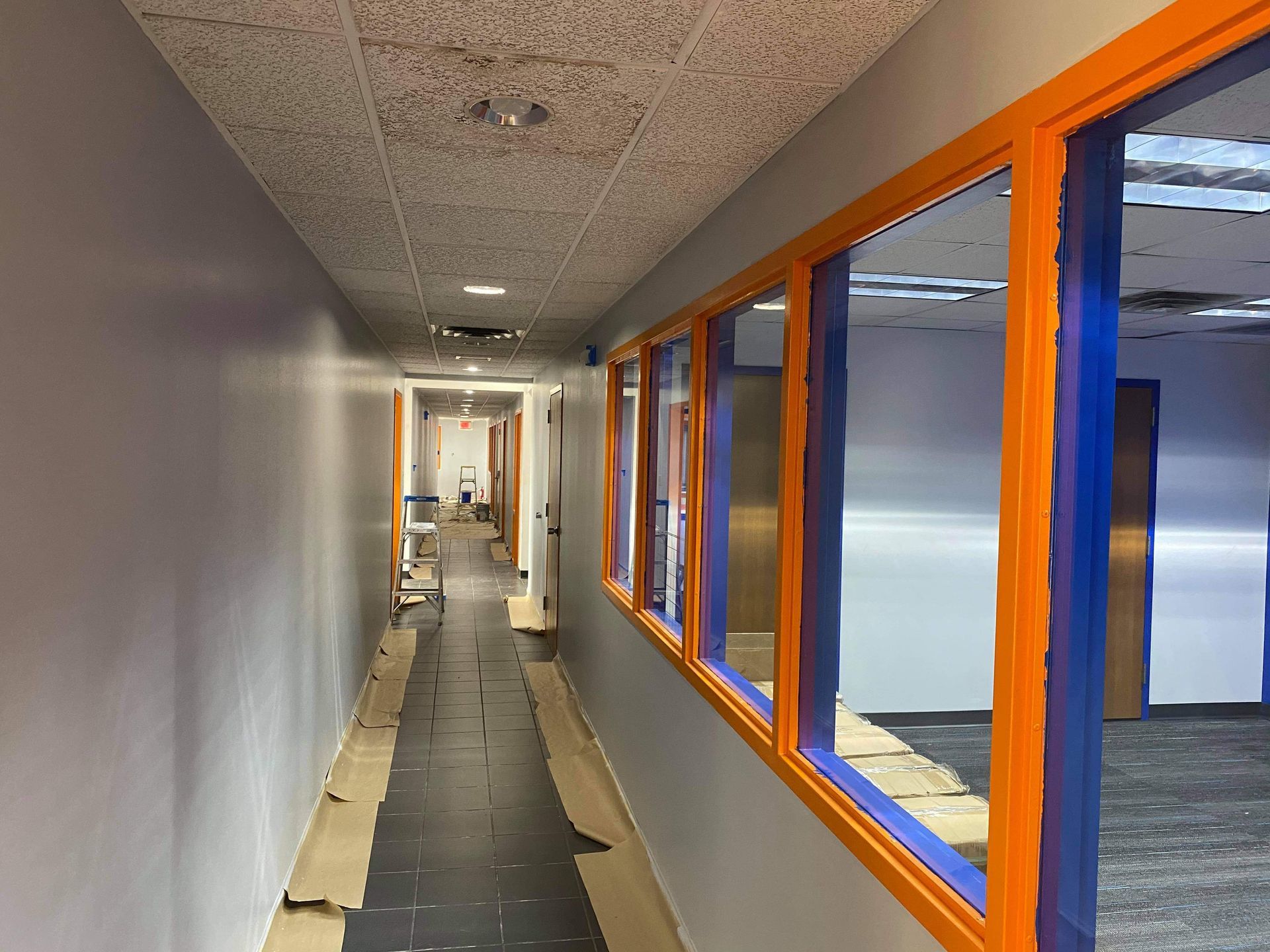 A long hallway with orange and blue windows