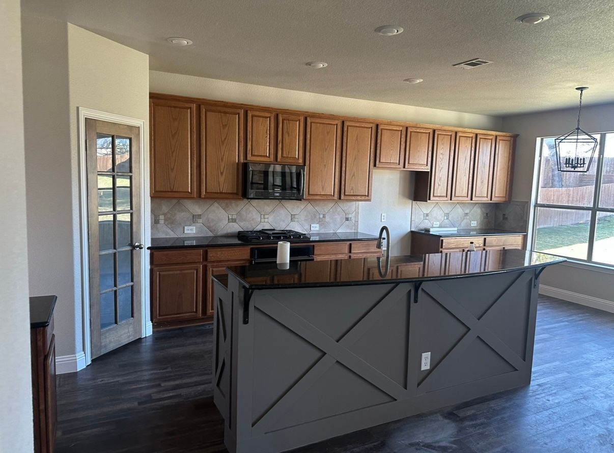 A kitchen with a large island and wooden cabinets