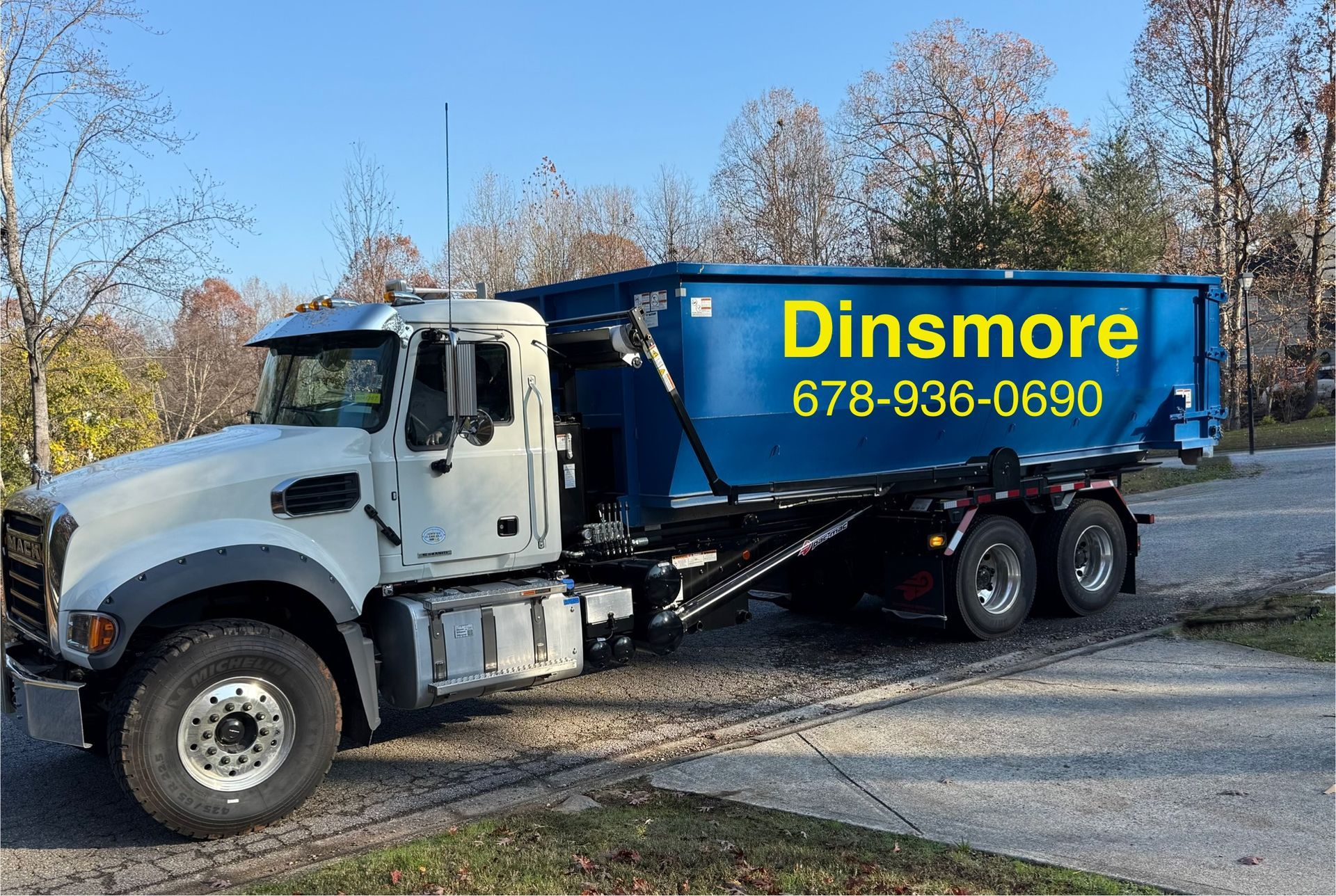 White truck with a blue dumpster;