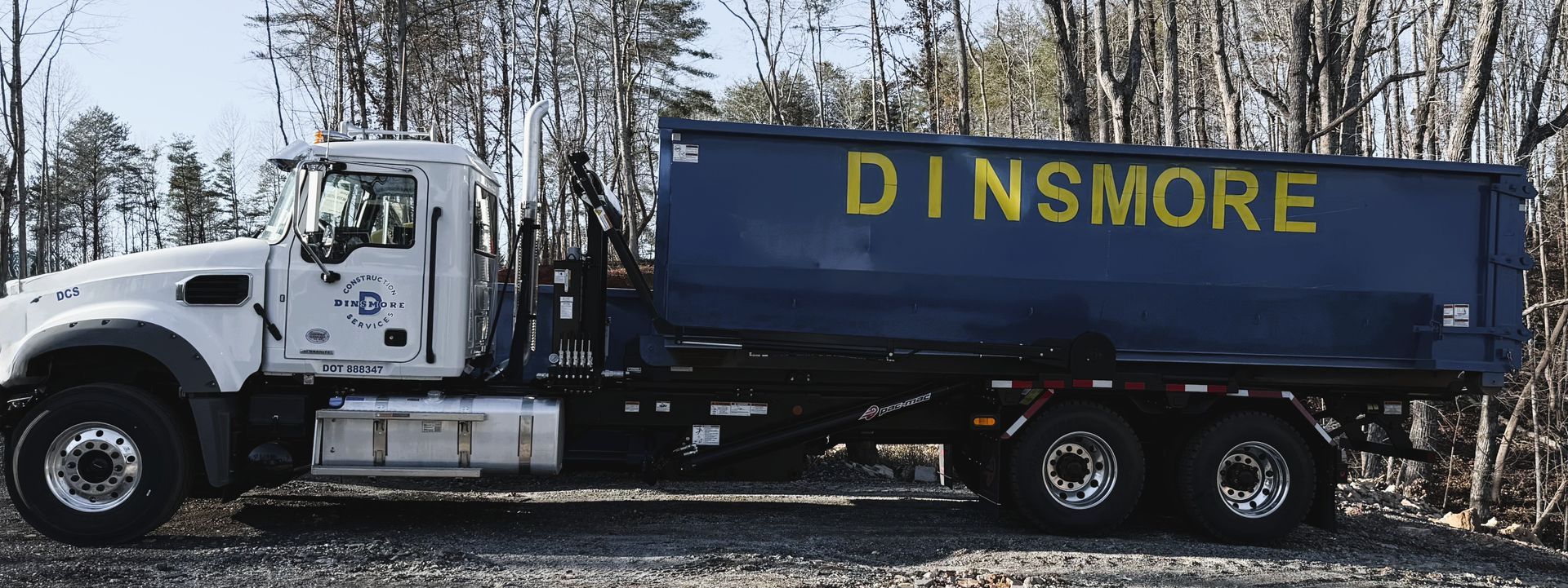 A white truck with a blue dumpster labeled 