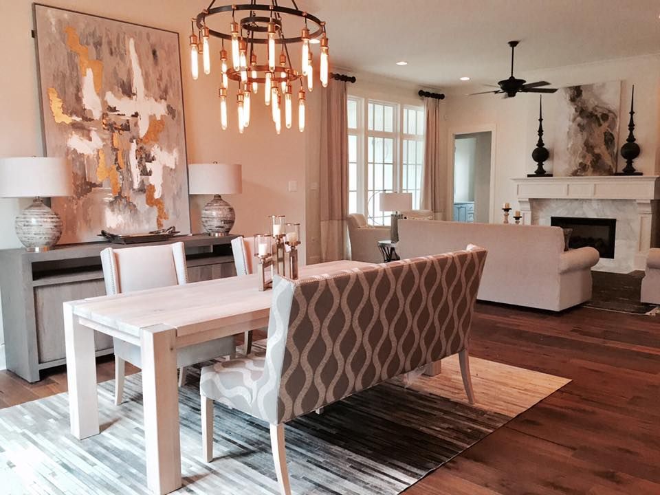 Dining room with table, chairs, buffet, large abstract art, and chandelier.