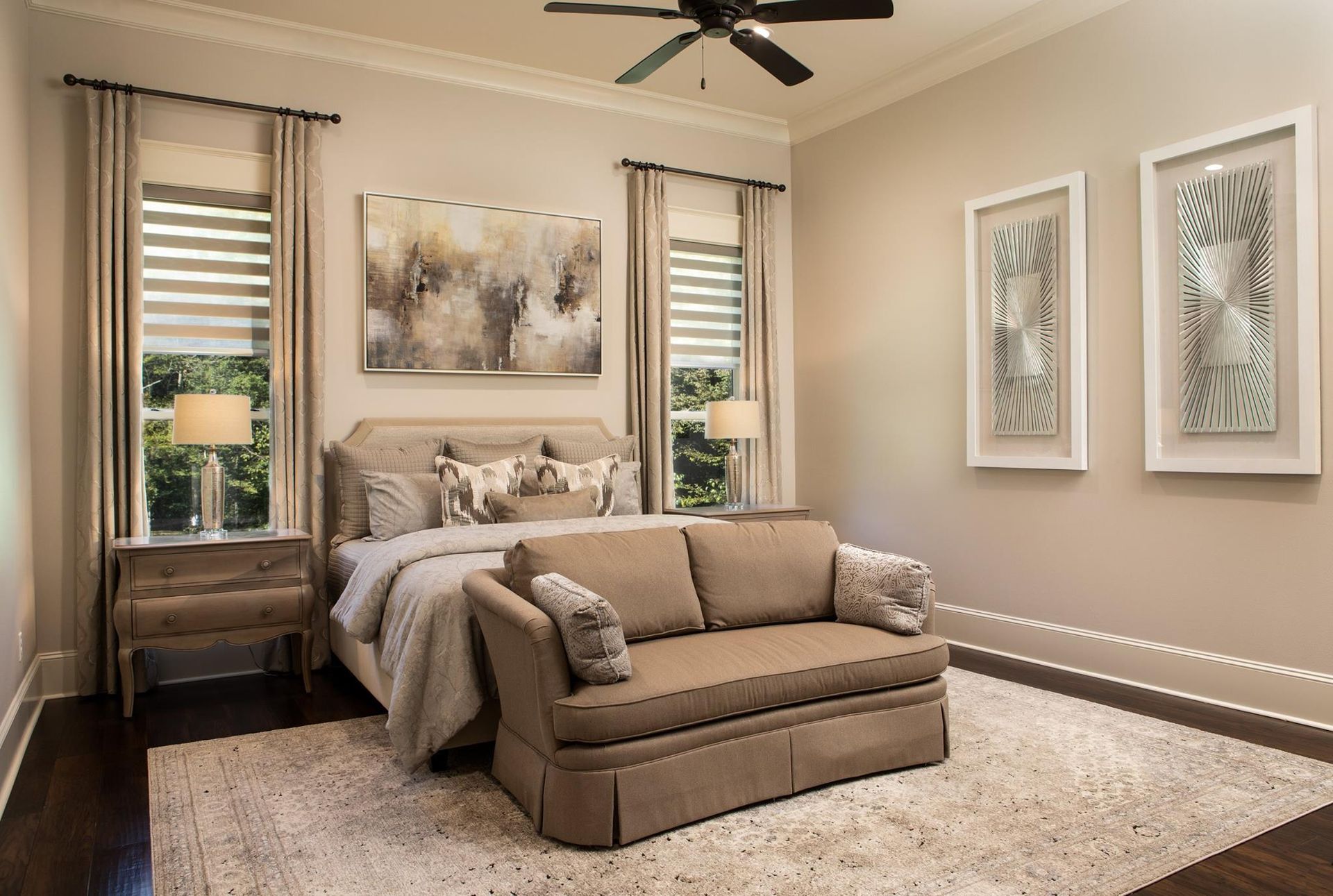 Bedroom with bed, sofa, and decorative wall art, neutral color scheme.