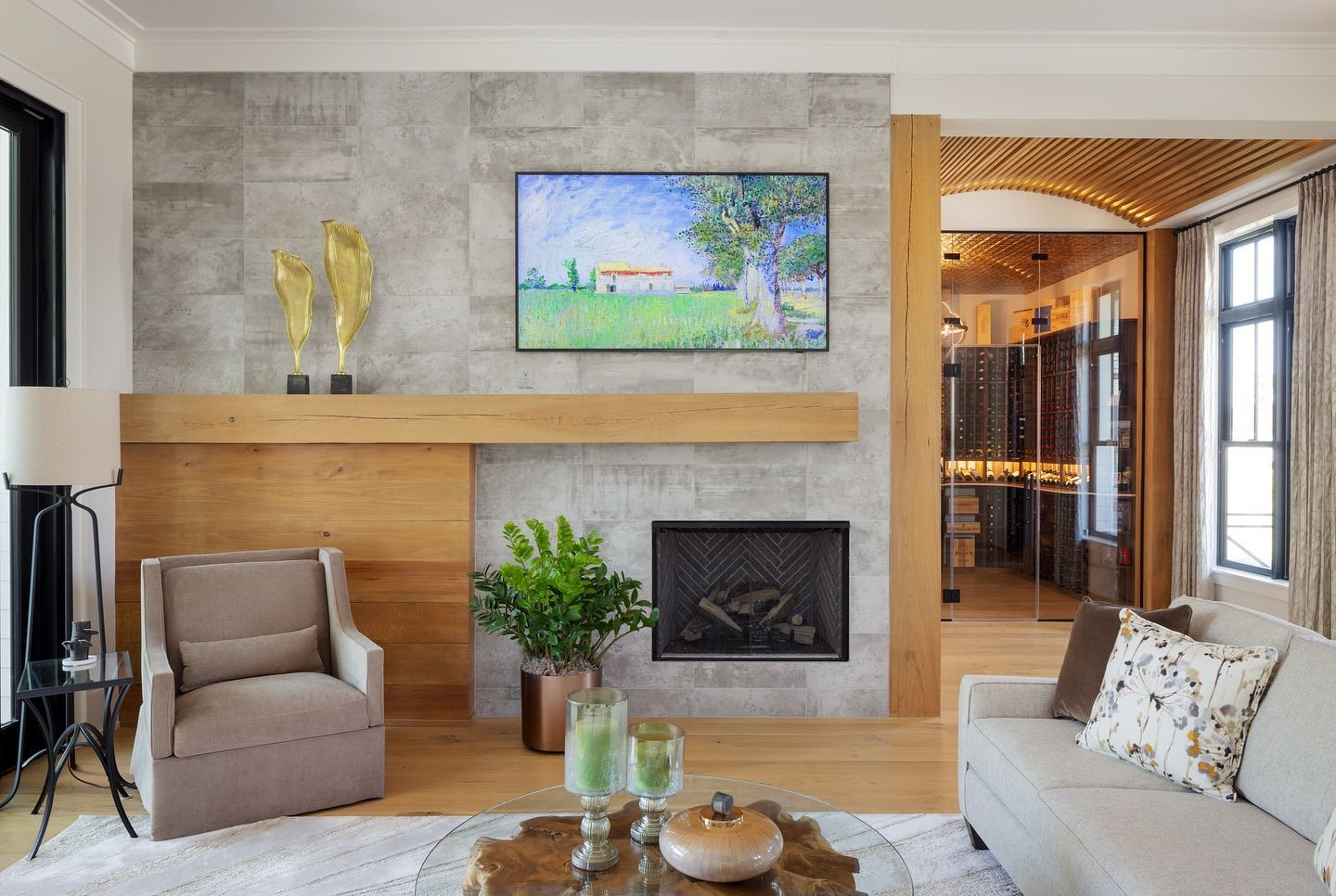 Living room with fireplace, artwork above, wooden accents, and modern furniture.