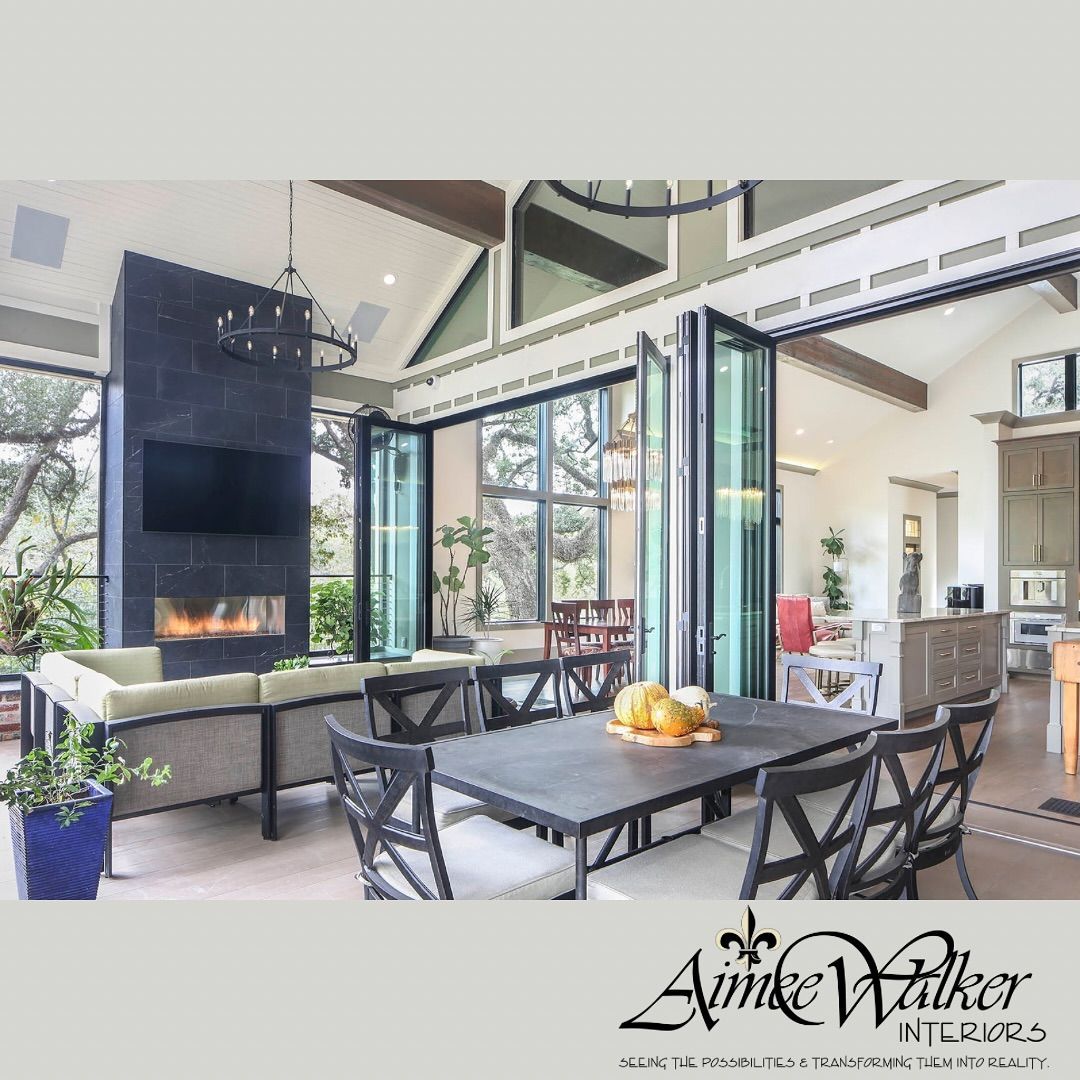 Outdoor living area with a dining table, fireplace, and folding glass doors.