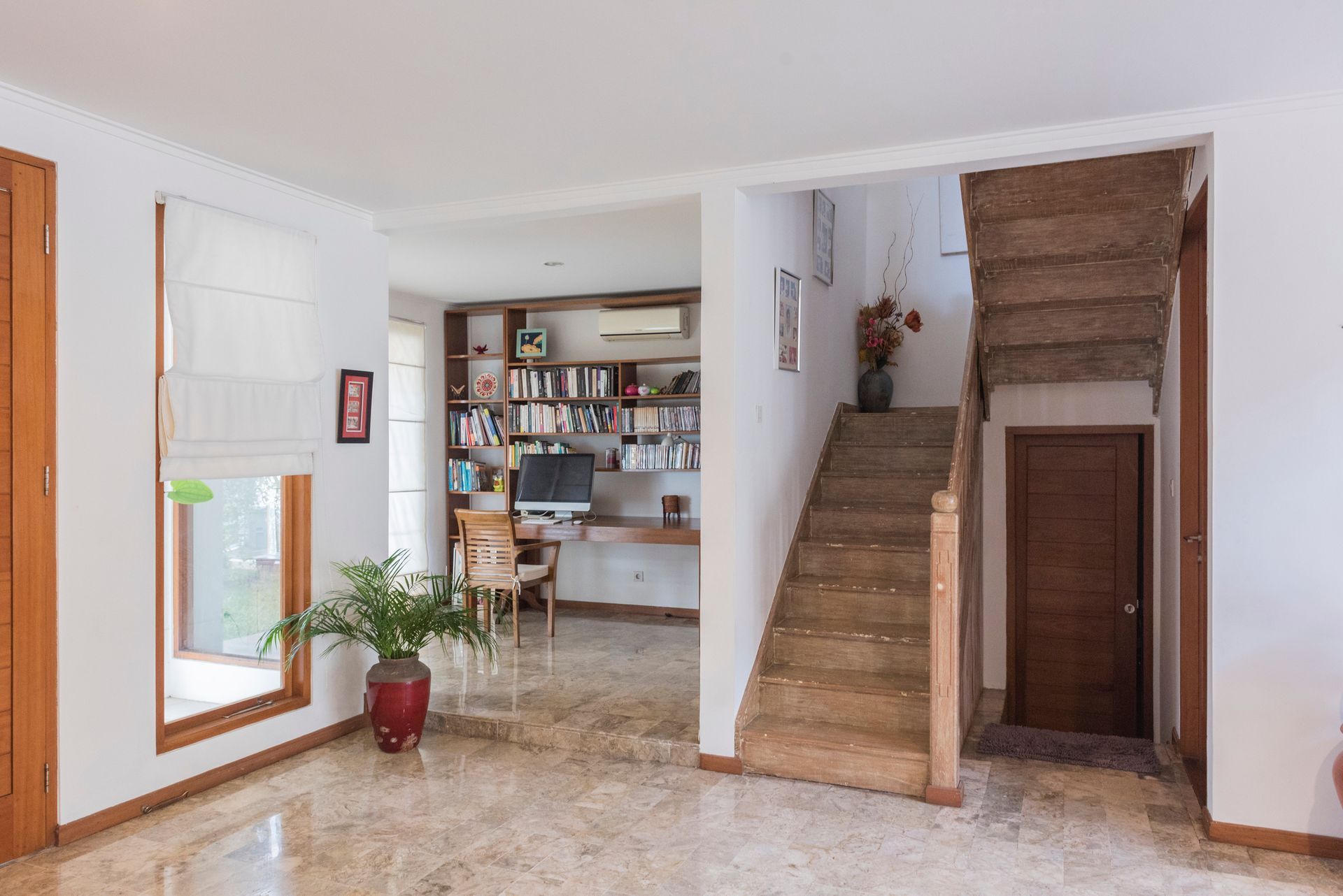 Bright interior with stairs, desk area, and a window.