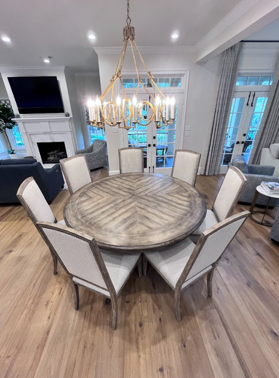 Dining room with six patterned chairs, a wooden table, and a decorative chandelier.