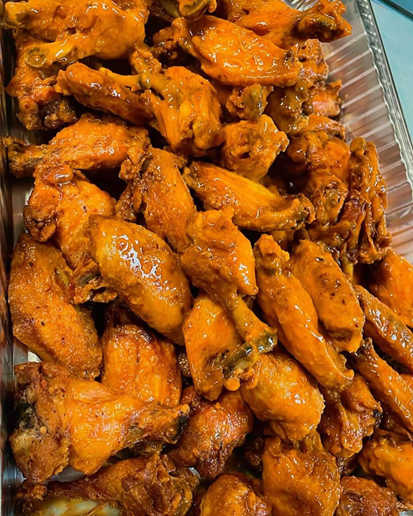 A wooden cutting board topped with fried cheese sticks and a bowl of ketchup.