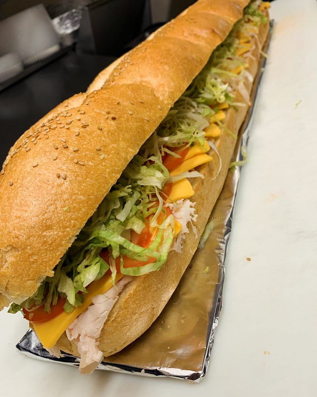 A panini sandwich is cut in half on a wooden cutting board.