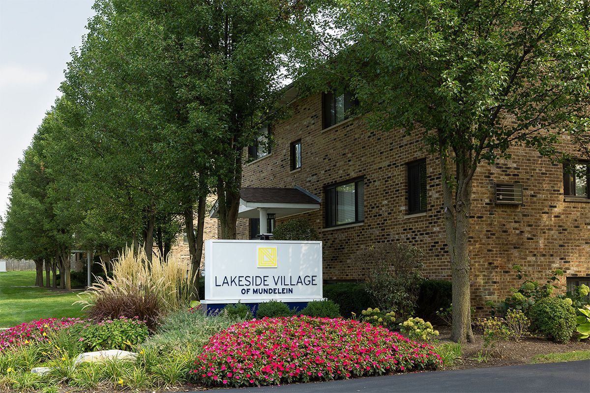 a brick apartment building with a sign in front of it .