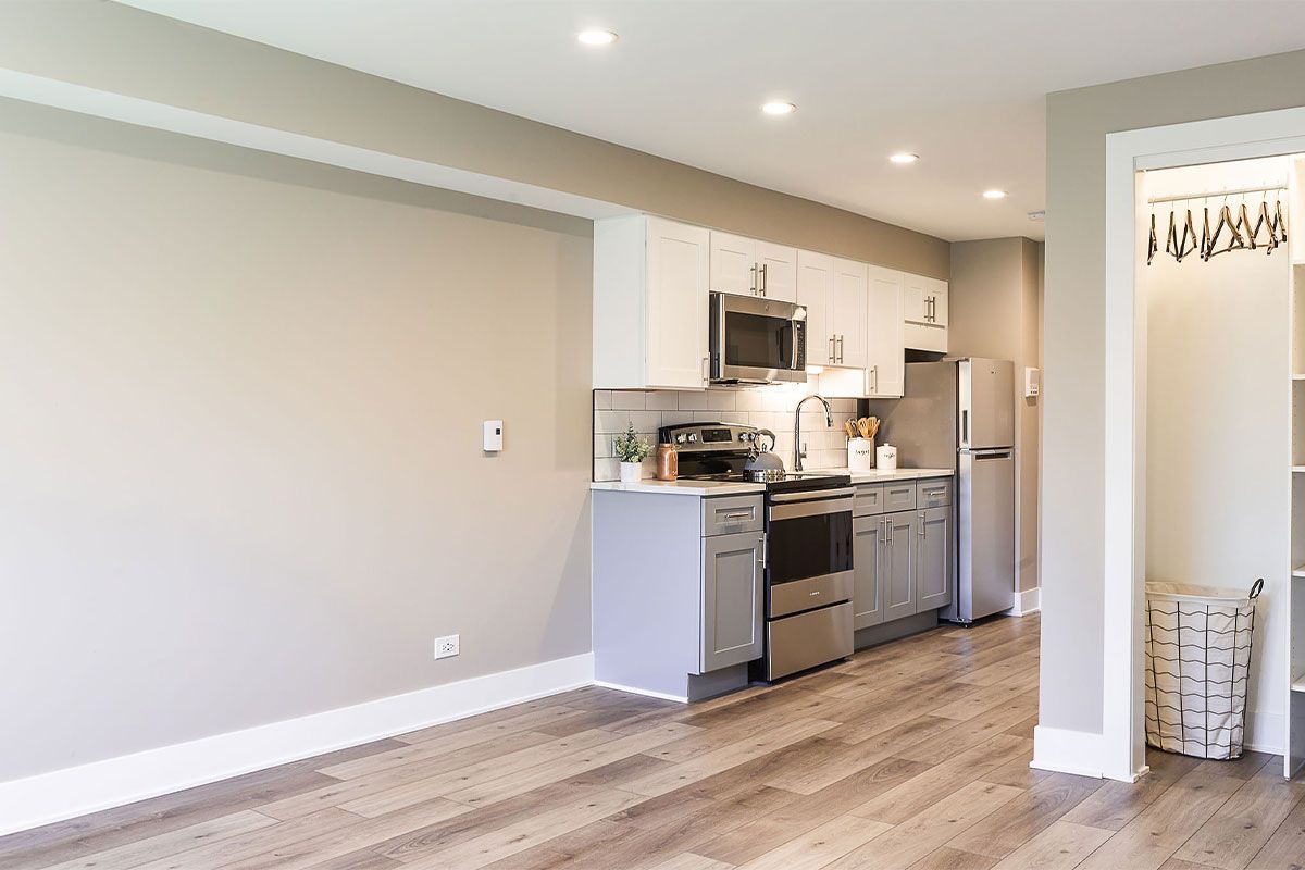 a kitchen with stainless steel appliances and wooden floors in a living room .