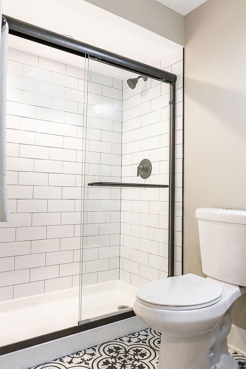 a bathroom with a toilet , shower and sliding glass door .