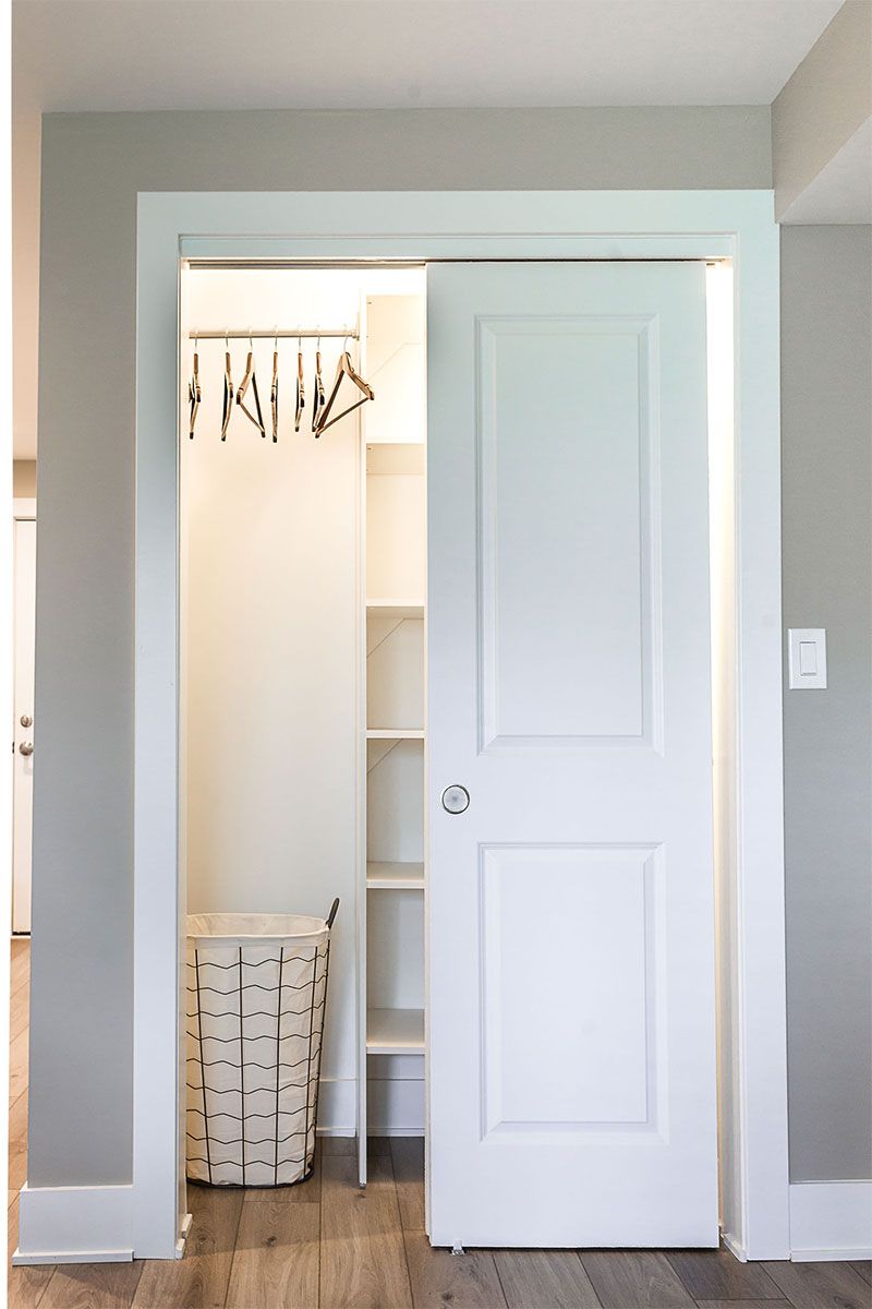 a closet with a sliding door and a laundry basket in it .
