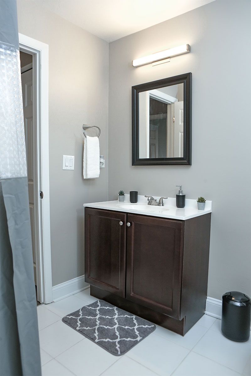 a bathroom with a sink , mirror , and towel rack .