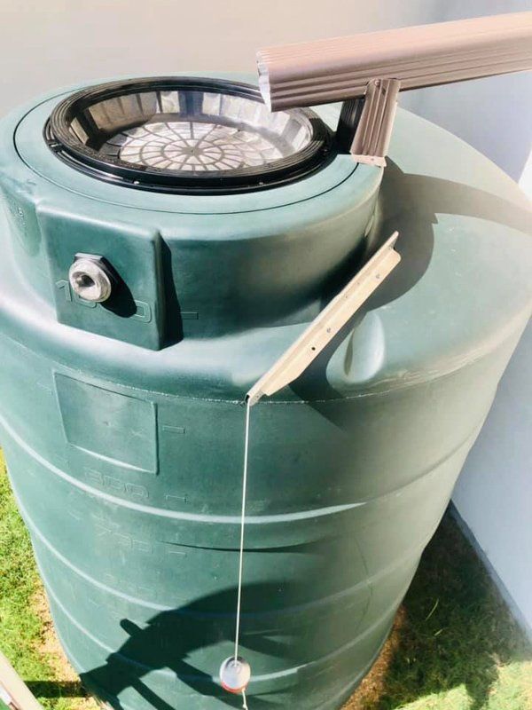 a green water tank with a hose attached to it
