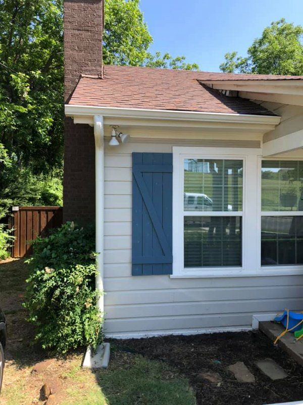 a white house with blue shutters on the windows
