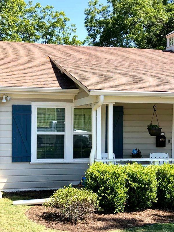 a white house with blue shutters and a porch