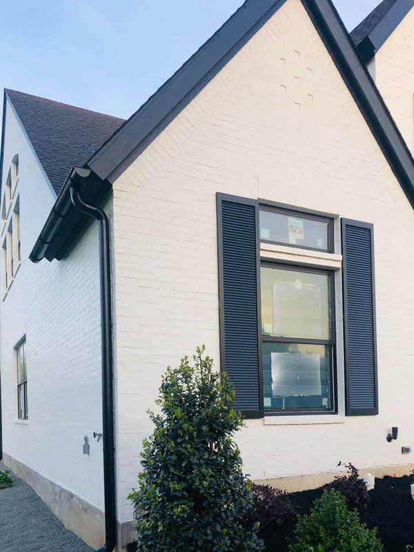a white house with black shutters on the windows