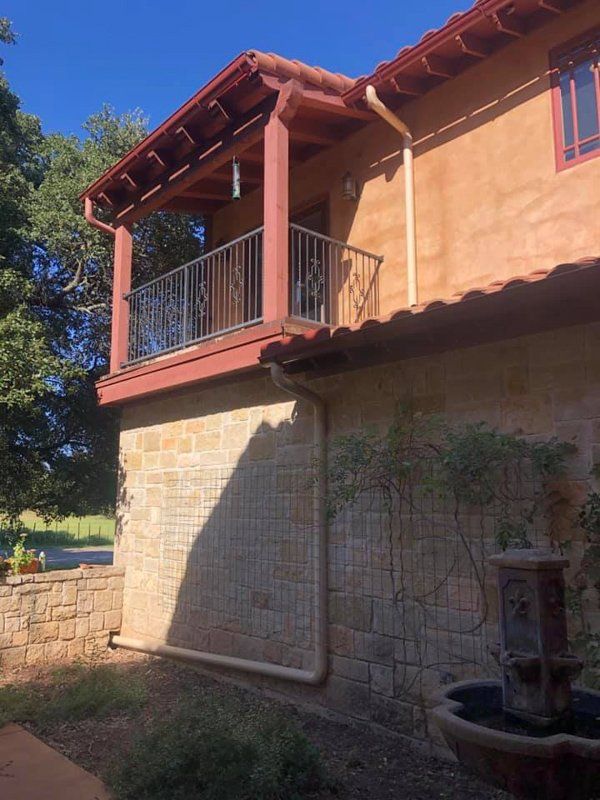 a house with a balcony and a fountain in front of it