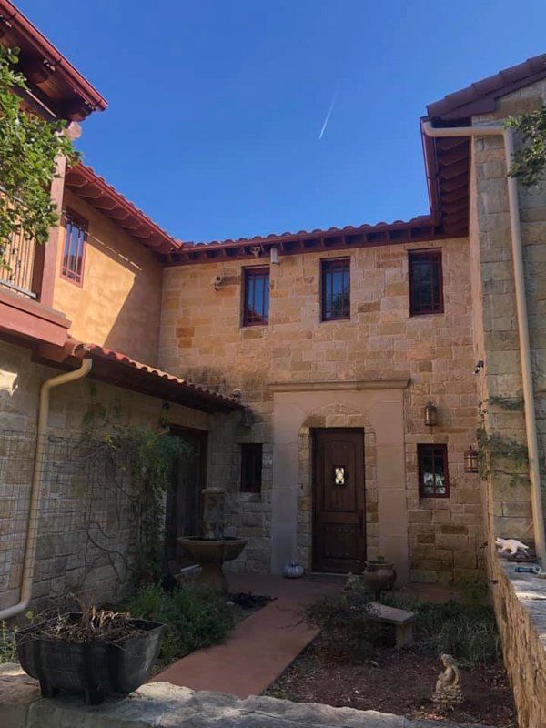 a large stone building with a wooden door and a fountain in front of it