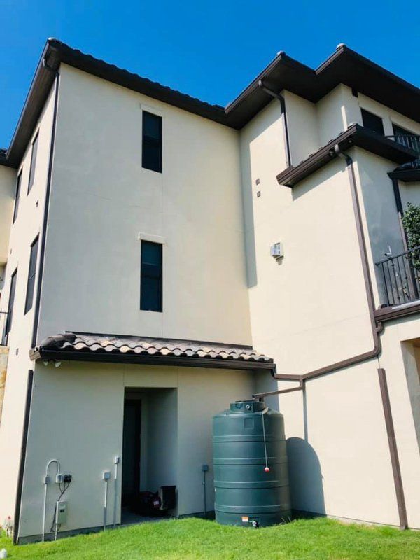 a large white building with a green water tank in front of it
