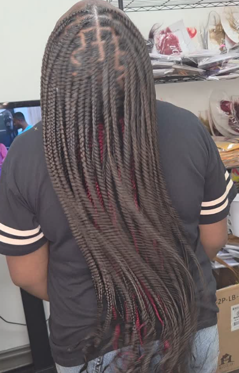 Person with long, dark braided hair, wearing a black shirt, facing away.