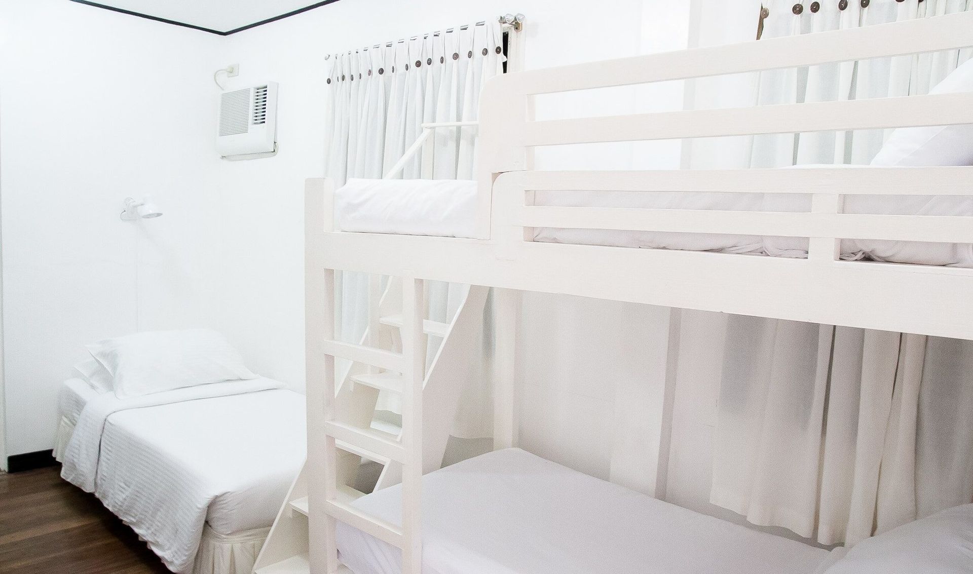 White room with bunk beds and a single bed.