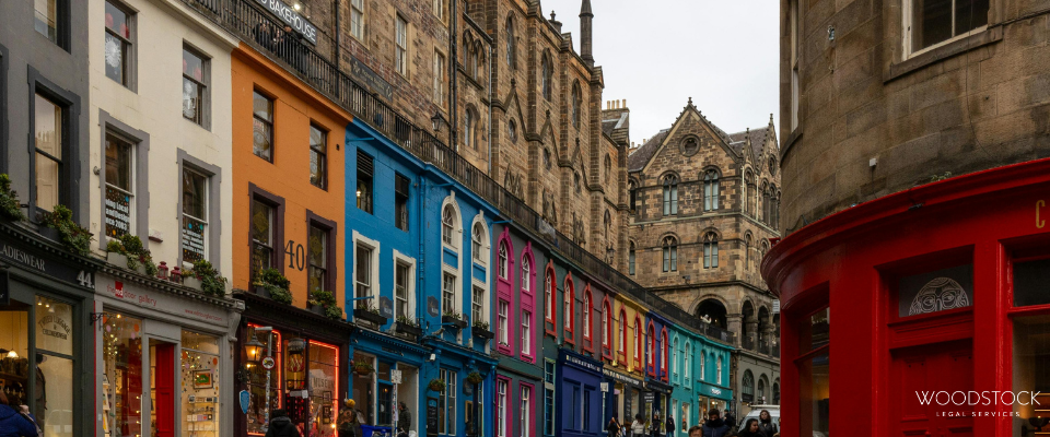 Colourful row of vibrant shopfronts along Victoria Street in Edinburgh with historic stone buildings