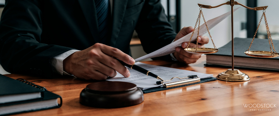 Solicitor reviewing legal documents at a desk with scales of justice and gavel, representing legal a